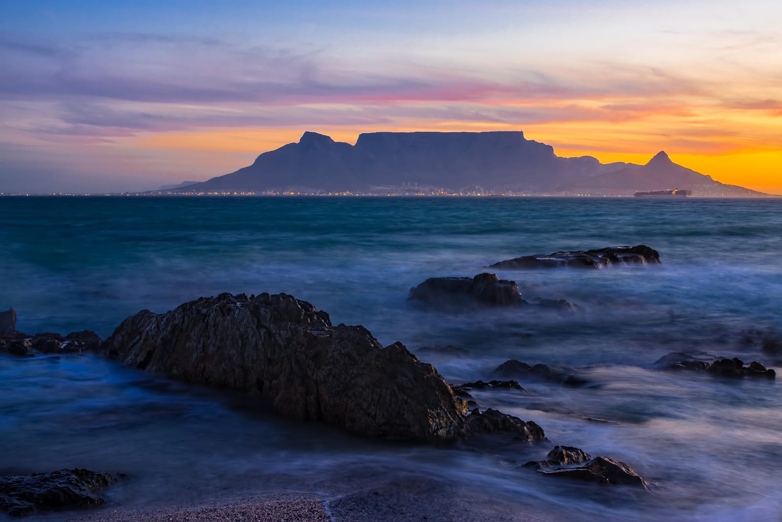 Der Tafelberg über der Table Bay, im Vordergrund Felsen im Wasser